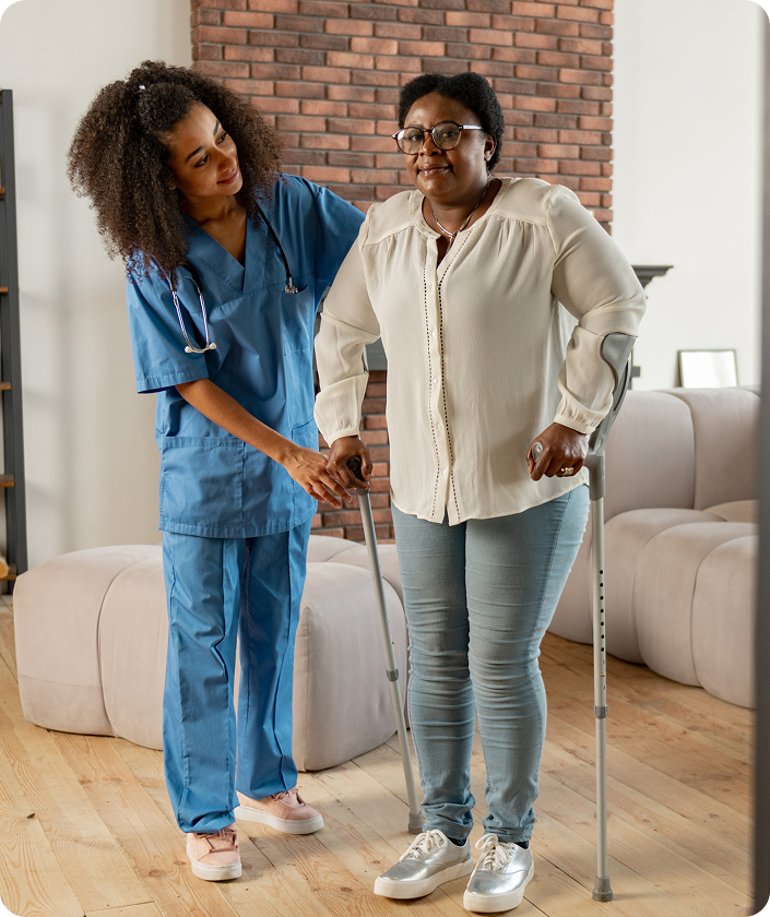 near-private-nurse-aged-dark-skinned-woman-making-first-steps-with-crutches-standing-near-private-nurse